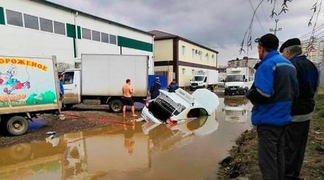 Автомобиль такси ушел под воду в краснодарской луже