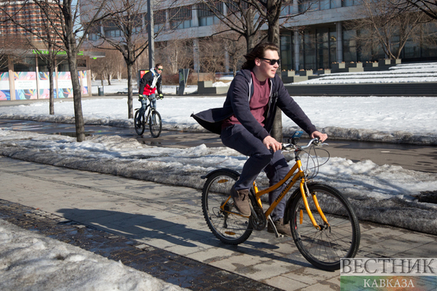 Велосипедист на очищенной от снега велодорожке