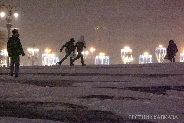 Люди во время снегопада на Красной площади в Москве