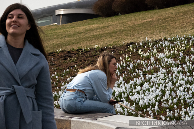 Отдыхающие в парке Зарядье рядом с поляной с пушкинией