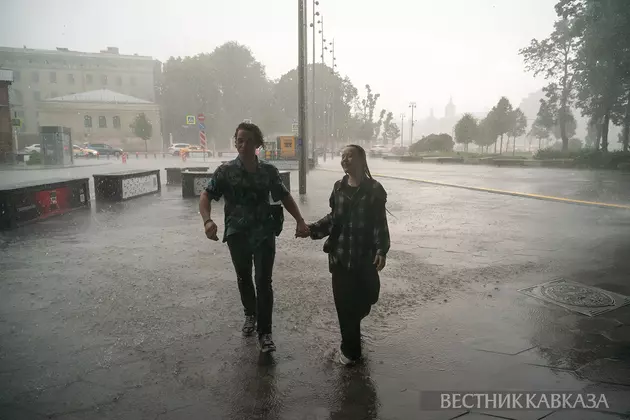 Люди во время сильного дождя в Москве