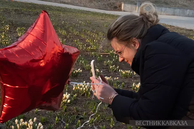 Девушка фотографирует цветы