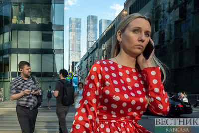 Девушка говорит по телефону на улице